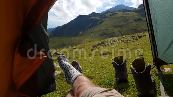 穿袜子的男腿在夏天的绿色山谷里的帐篷里欢快地移动视频的预览图