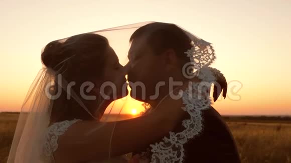 年轻的已婚夫妇在日落时亲吻和拥抱男女婚姻生活视频的预览图