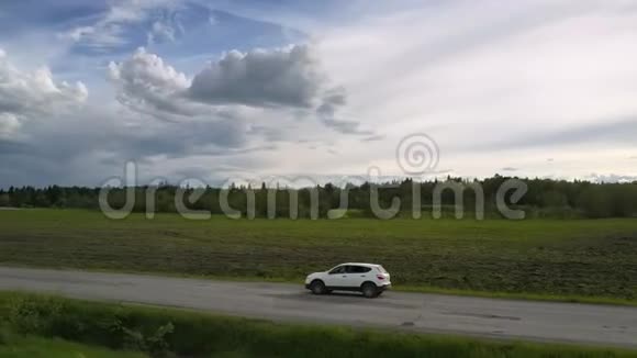 车辆沿旧柏油路行驶行驶在图案云下视频的预览图