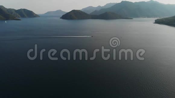 在美丽的岛屿的背景下船从左到右在海上航行照相机从下往上升视频的预览图