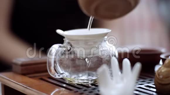 通过一个特殊的筛子把美味的茶倒进茶壶里中国茶道仪式视频的预览图