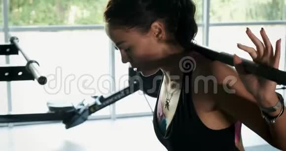 强壮漂亮的女人在运动俱乐部用杠铃训练肌肉现代体育运动中的女运动员视频的预览图