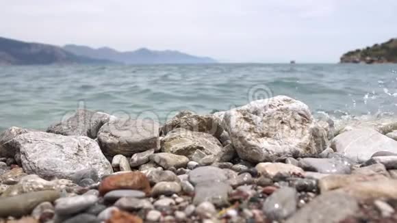 海水缓慢地拍打着海岸上的石头视频的预览图