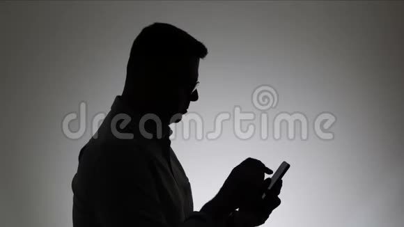 一个男人在白色背景上的剪影一个男人在电话里留言女人用智能手机上网视频的预览图