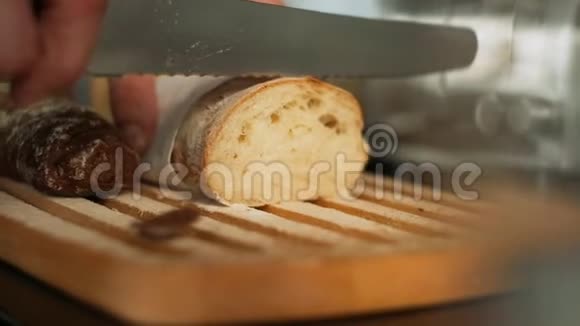 在木制的面包板上用刀切割法国面包视频的预览图