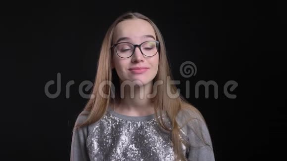 年轻漂亮的女时髦女郎戴着眼镜微笑着挥手打招呼直视着镜头的特写镜头视频的预览图