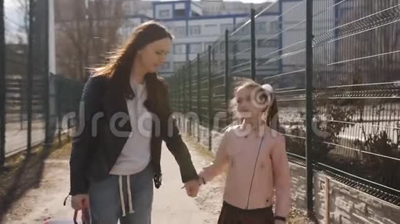 妈妈和小女儿一起上学母亲背着小瞳的背包视频的预览图