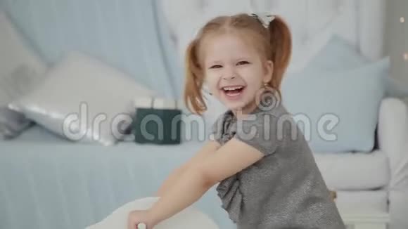 非常漂亮的小女孩骑着一匹木马在新年房间里微笑视频的预览图