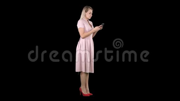 金发少女穿着粉色短信在她的智能手机阿尔法频道视频的预览图