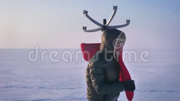 穿着温暖外套和引擎盖的运动员在雪地背景上绕着他肩膀上的一把红色椅子走来走去视频的预览图
