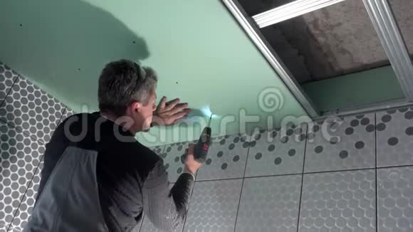 建筑工人用螺丝刀组装天花板和固定干壁视频的预览图