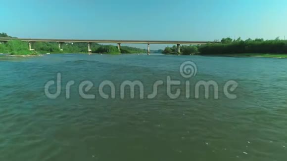 在阳光明媚的夏日早晨在清新的泡沫河流上空低空飞行4K视频的预览图