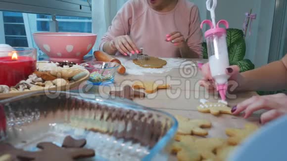 厨房里的年轻女人涂了姜黄色的圣诞姜饼视频的预览图