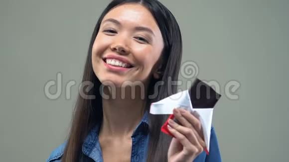 微笑亚洲女人吃巧克力棒记忆力和情绪改善效果视频的预览图