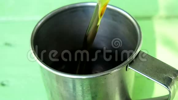 远足茶从水壶里倒入一个铁杯里视频的预览图