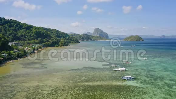 菲律宾巴拉望岛的ElNido4K无人驾驶飞机看到的船只停泊在海湾与清澈的翡翠绿水视频的预览图
