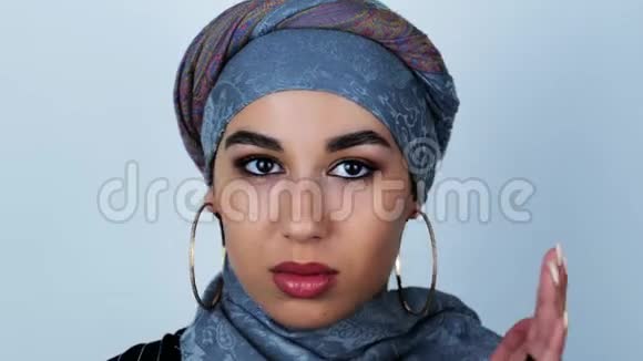 年轻美丽的阿拉伯女人在与孤立的白色背景意见不合时转过头来视频的预览图