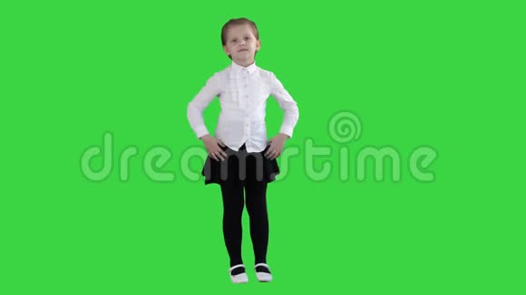 可爱的小女孩穿着白色连衣裙在绿色屏幕上的相机上摆姿势Chroma键视频的预览图