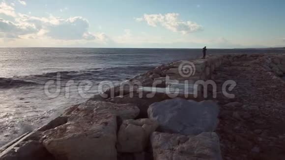 女孩远离海边的岩石海岸视频的预览图