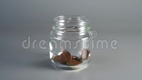 硬币硬币落入一罐储蓄和过量视频的预览图