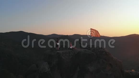日落时一群游客的鸟瞰图赛尔夫和朋友在山顶视频的预览图