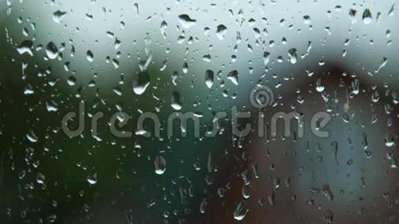 雨滴在雨中从潮湿的窗户表面流下来视频的预览图