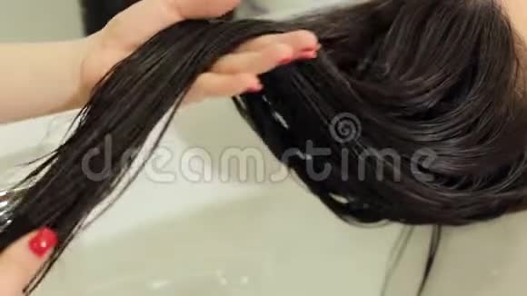 特写美发师溅湿发女护油头发护理视频的预览图