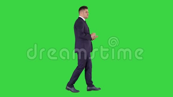 年轻积极的白种人商人在绿色屏幕上行走和制作清单Chroma键视频的预览图