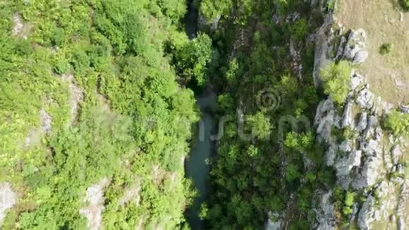 空中无人驾驶飞机从上往下拍摄的峡谷与河流和瀑布视频的预览图