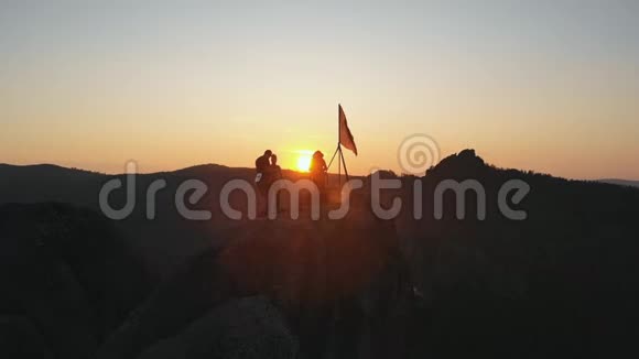 日落时山顶上徒步旅行者的剪影视频的预览图