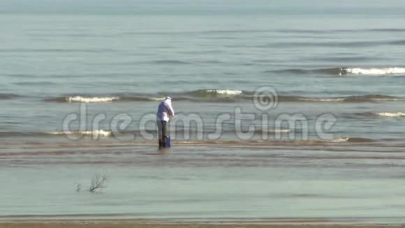 一个人站在海浪中在近海捕鱼视频的预览图