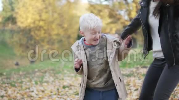 妈妈和儿子在秋天的森林里散步视频的预览图