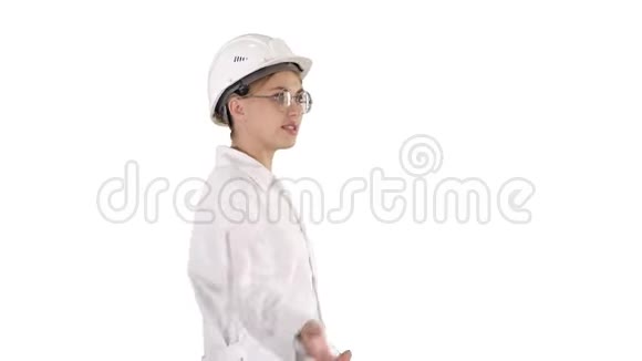 穿着实验室工作服戴着安全帽的年轻科学家在白色背景下散步和说话视频的预览图