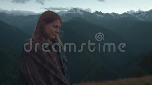 一个年轻的浪漫女孩的画像在山的背景上一个美丽的女孩在雪后看日落视频的预览图