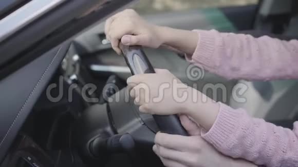 特写手中的父女坐在车轮后面的豪车父亲教女孩开车视频的预览图