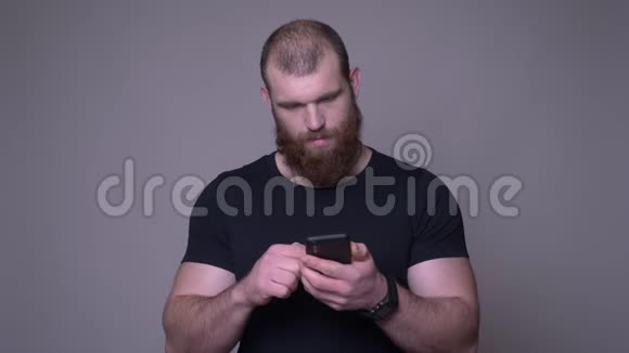 在镜头前一位长着胡须的白种人成年英俊肌肉发达的特写镜头在手机上视频的预览图