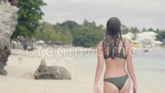 旅游妇女穿着泳衣在沙滩上散步而暑假幸福的女人休息在海岸后景女孩视频的预览图