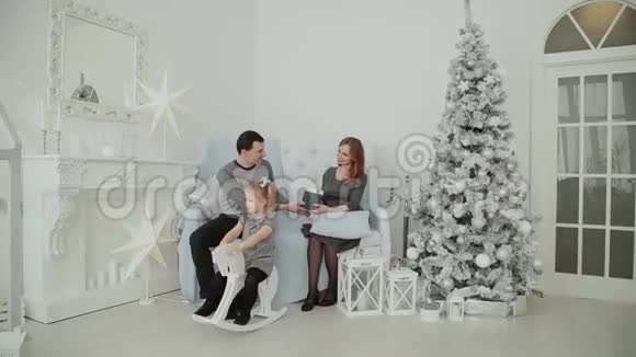 一家三口坐在沙发上在2019年圣诞节除夕聊天视频的预览图