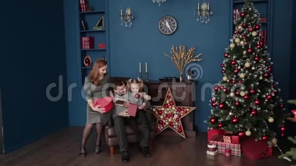 一家三口在壁炉旁打开新年礼物2019年圣诞节视频的预览图