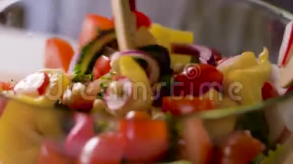 汤匙搅拌碗中的新鲜蔬菜沙拉视频的预览图