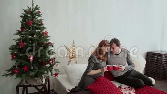 怀孕的女孩和她的丈夫在床上新年风格2019年圣诞节视频的预览图