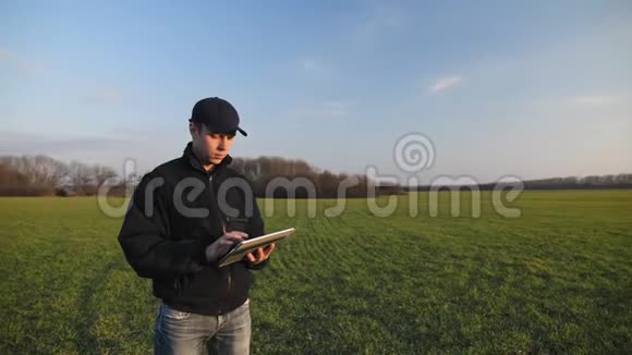 在麦田里拿着便携式平板电脑的男农视频的预览图