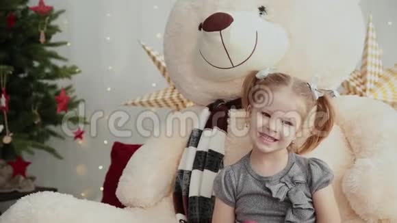 小而漂亮的女孩在玩一只新的一年熊视频的预览图