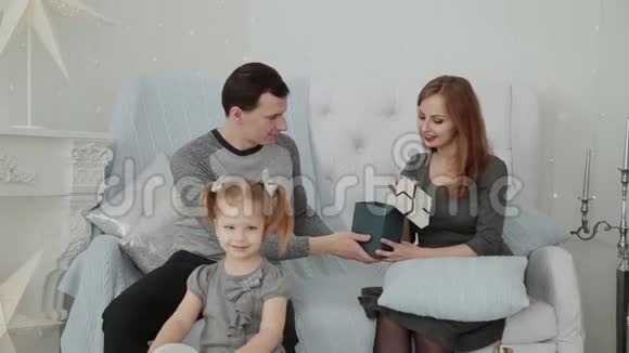 一家三口坐在沙发上在2019年圣诞节除夕聊天视频的预览图