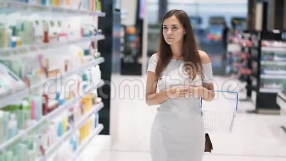 美丽的女孩带着篮子去化妆品商店慢动作稳拍视频的预览图