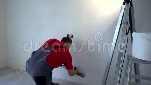 施膏者用刀在墙上施膏新公寓装修视频的预览图