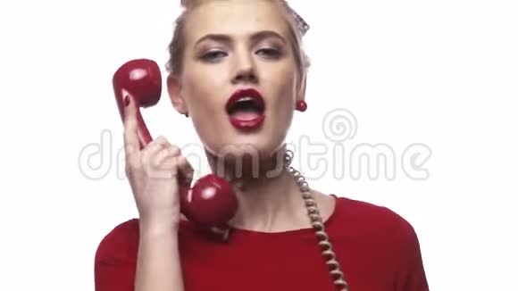 身穿红裙的金发女孩手里拿着有线电话在跳舞玩得很开心视频的预览图
