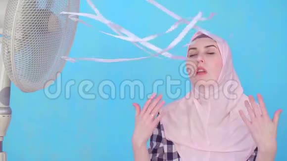 年轻的穆斯林妇女遭受炎热的天气冷却风扇慢莫视频的预览图