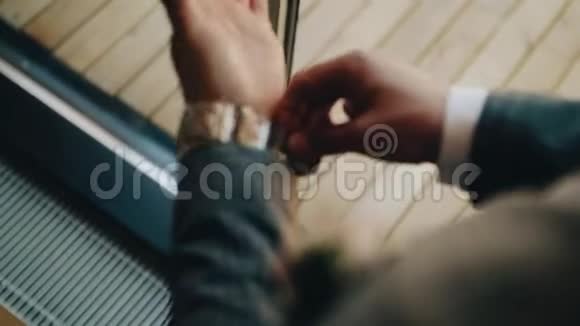 一个站在明亮的大窗户前的人把一只大机械手表放在手上美女配饰视频的预览图
