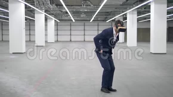 一个商人在办公室里戴着VR耳机跳起来视频的预览图